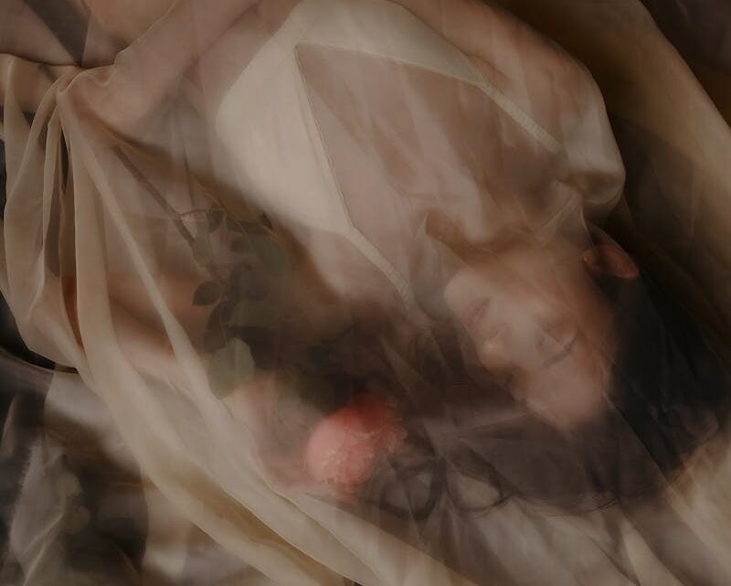 Woman in Lingerie Lying Down under Fabric