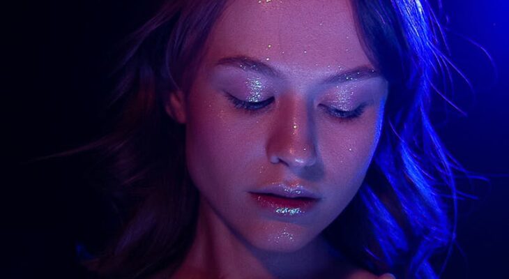 Thoughtful female in bra with glowing face and closed eyes